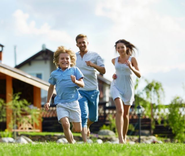 Glückliche Familie rennt auf der Wiese